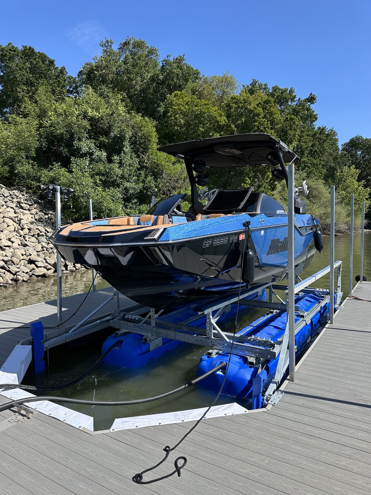 Blue boat positioned on HydroHoist bunks within a dock slip